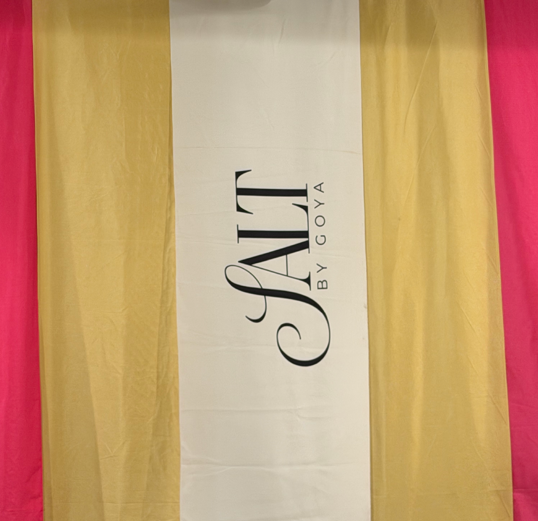 SALT by Goya festival banner against coloured fabric