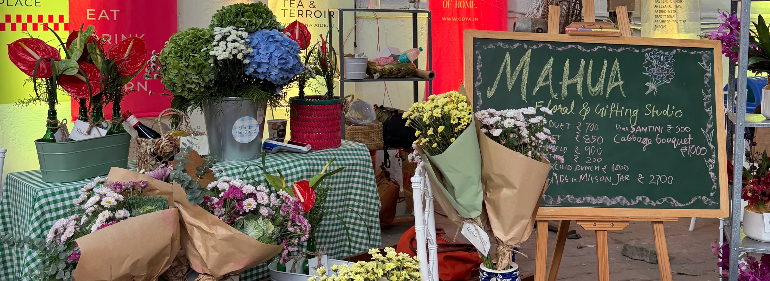 Flowers and a chalkboard at Mahua's SALT by Goya stall